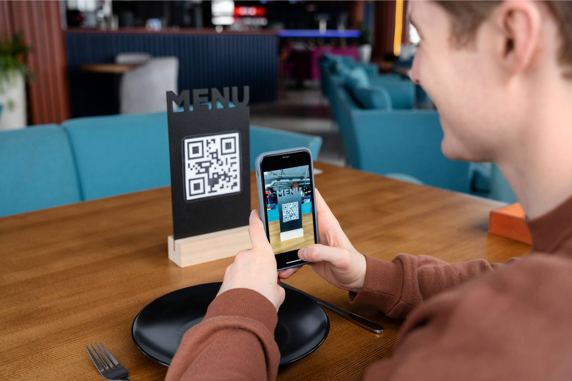 Kunde scannt mit einem QR Code die digitale Speisekarte in einem Restaurant